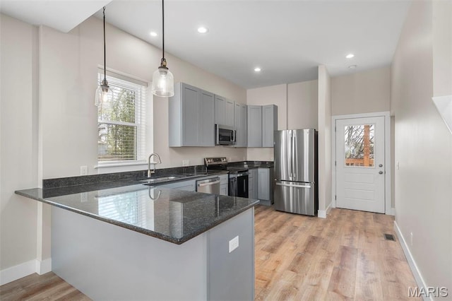 6800 Minnesota Ave, Saint Louis, MO 63111 - kitchen with appliances with stainless steel finishes, a sink, a peninsula, dark stone counters, and gray cabinets
