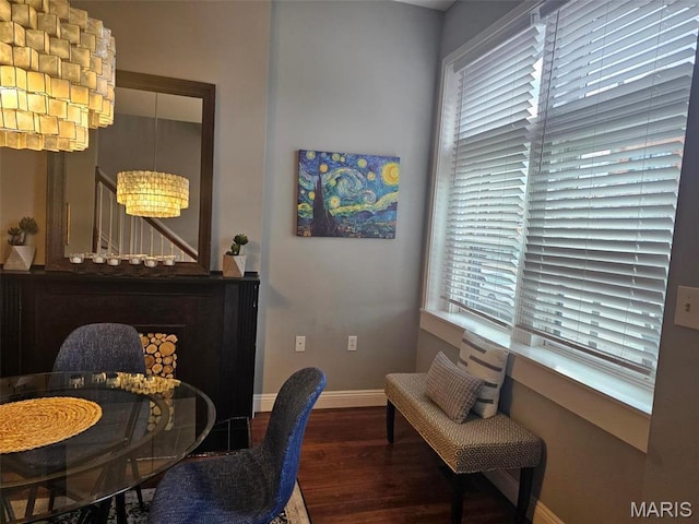 dining space with wood finished floors, a chandelier, and baseboards