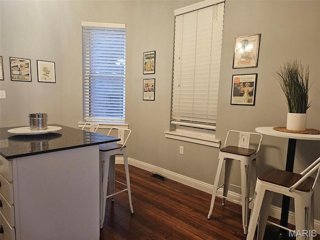 dining area with dark wood-style floors and baseboards