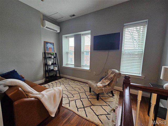 living area featuring a wall mounted AC, wood finished floors, and baseboards