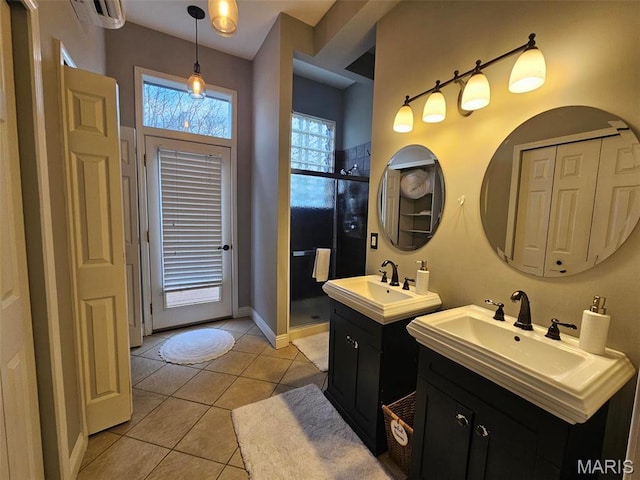 full bath with a stall shower, tile patterned floors, two vanities, baseboards, and a wall mounted air conditioner