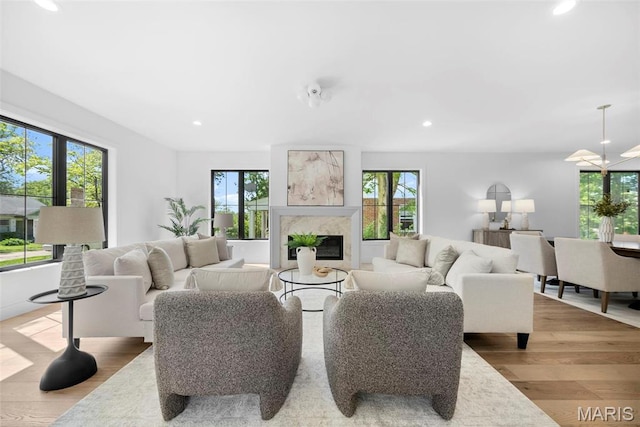 living room with light wood-style floors, a premium fireplace, and recessed lighting