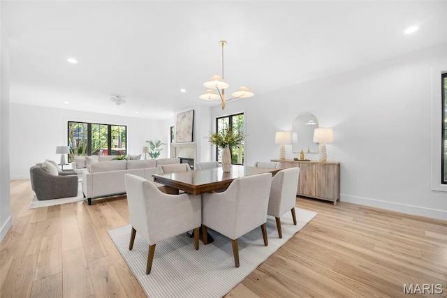dining area featuring light wood finished floors, recessed lighting, baseboards, and a chandelier