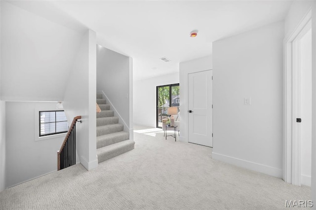 staircase featuring carpet flooring and baseboards