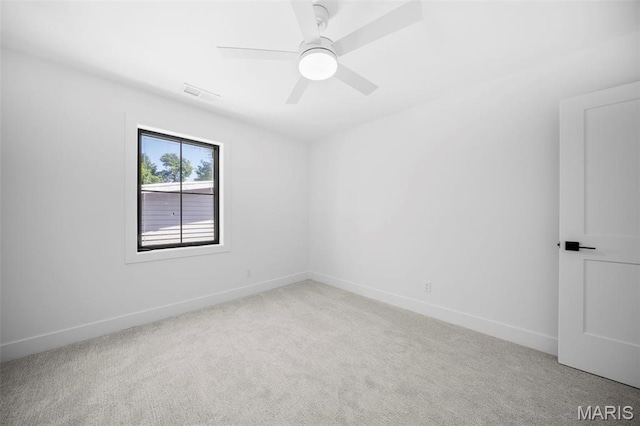 carpeted empty room with baseboards and a ceiling fan
