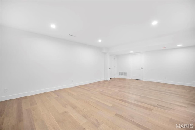 finished basement featuring light wood-type flooring, recessed lighting, and baseboards