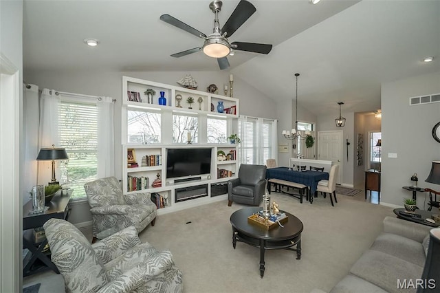 living area featuring lofted ceiling, a ceiling fan, carpet flooring, a chandelier, and baseboards