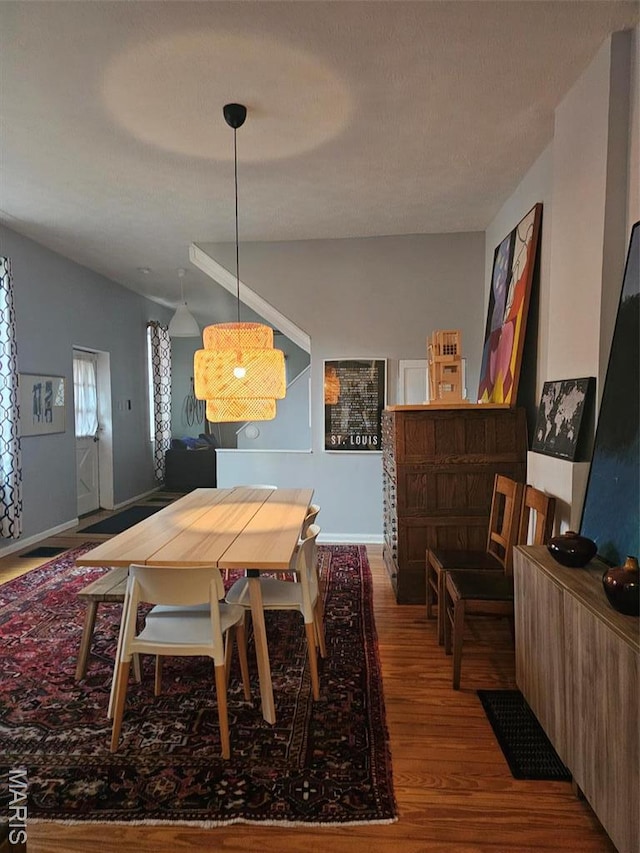 dining space with wood finished floors and baseboards