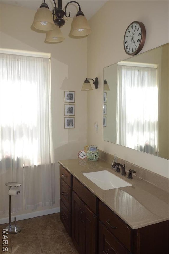 bathroom featuring plenty of natural light, vanity, tile patterned flooring, and a chandelier