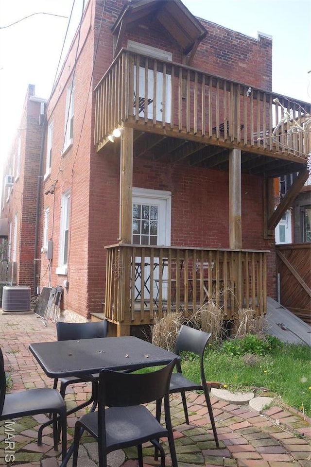 view of patio / terrace with outdoor dining space, a balcony, a wooden deck, and cooling unit