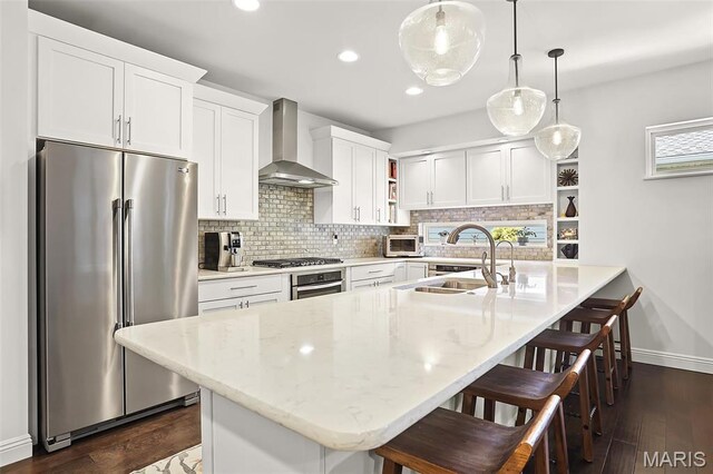 1420 Randle St, Edwardsville, IL 62025 - kitchen featuring appliances with stainless steel finishes, wall chimney range hood, a sink, open shelves, and a breakfast bar area