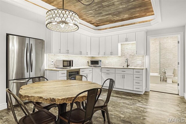 1420 Randle St, Edwardsville, IL 62025 - kitchen with appliances with stainless steel finishes, a tray ceiling, wooden ceiling, light countertops, and white cabinets