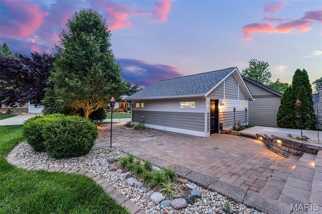 1420 Randle St, Edwardsville, IL 62025 - property exterior at dusk with a patio area and a shingled roof