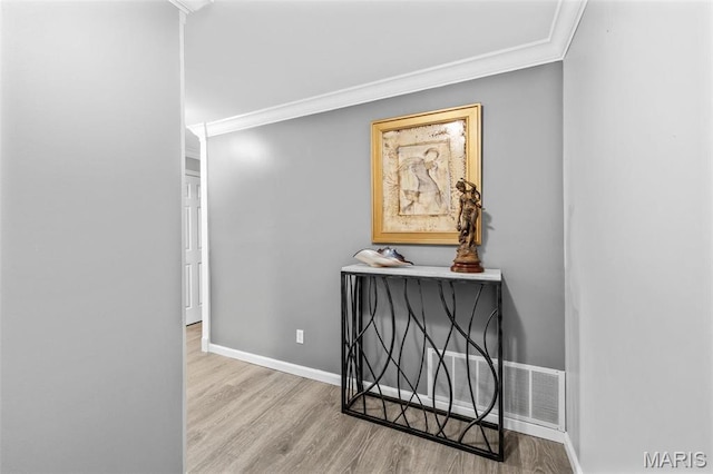 hallway featuring crown molding, wood finished floors, and baseboards