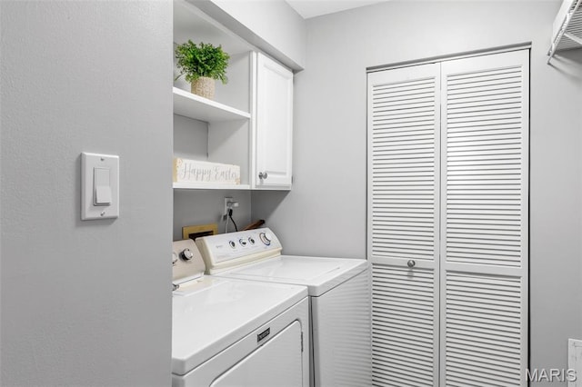 clothes washing area with cabinet space and washing machine and dryer