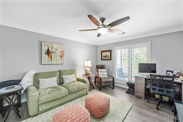 living area with a desk, a ceiling fan, crown molding, and light wood-style floors