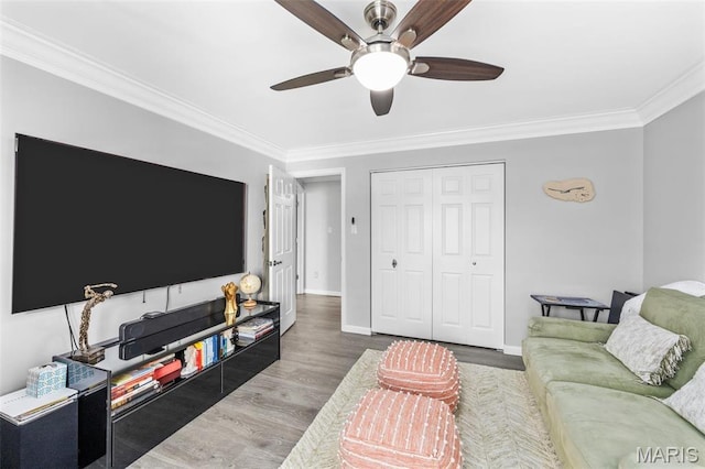 living area featuring crown molding, a ceiling fan, wood finished floors, and baseboards