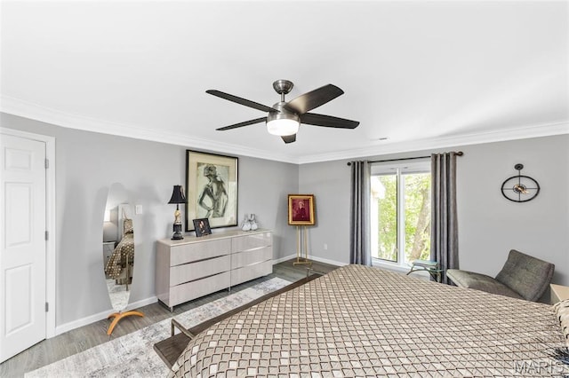 bedroom featuring wood finished floors, ornamental molding, baseboards, arched walkways, and ceiling fan