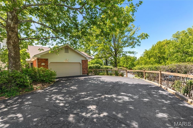 959 N Spoede Rd, Creve Coeur, MO 63146 - view of side of home featuring driveway, brick siding, and an attached garage
