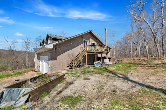 14742 Madison Ln, Wright City, MO 63390 - view of property exterior with brick siding, stairway, a wooden deck, and a garage