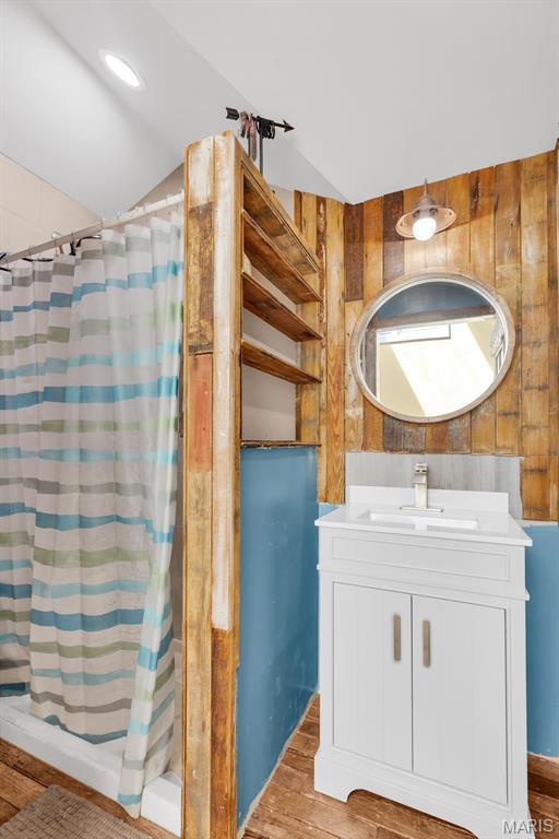 14742 Madison Ln, Wright City, MO 63390 - full bathroom with wood finished floors, vanity, a shower with shower curtain, and vaulted ceiling