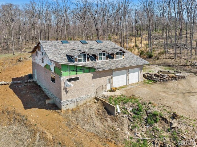 14742 Madison Ln, Wright City, MO 63390 - view of side of home featuring stucco siding, driveway, and a garage