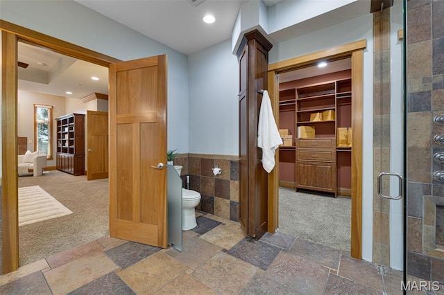 10711 Kennerly Rd, Saint Louis, MO 63128 - full bath with a shower stall, toilet, stone tile floors, recessed lighting, and tile walls