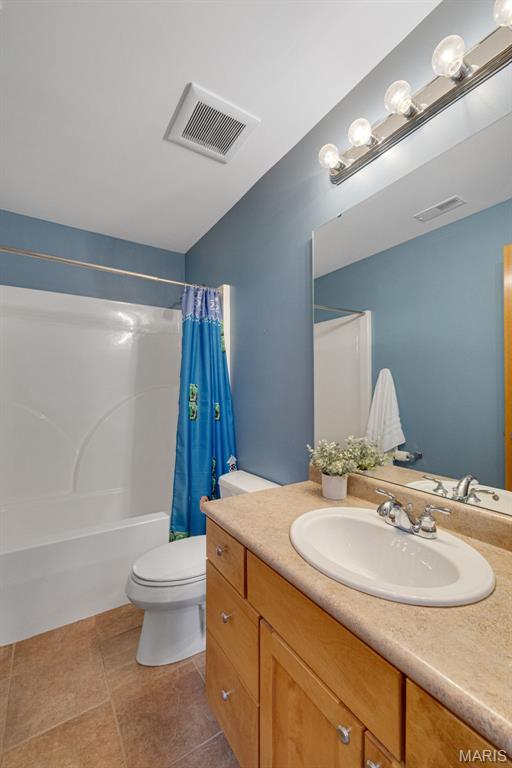 10711 Kennerly Rd, Saint Louis, MO 63128 - full bathroom featuring vanity, toilet, shower / tub combo, and tile patterned flooring