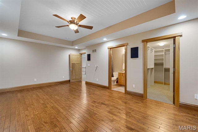 10711 Kennerly Rd, Saint Louis, MO 63128 - unfurnished bedroom with baseboards, light wood-style flooring, a spacious closet, recessed lighting, and connected bathroom