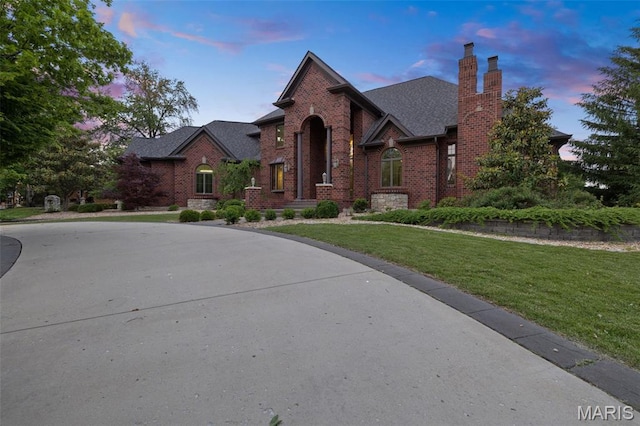 10711 Kennerly Rd, Saint Louis, MO 63128 - view of front facade with brick siding, a chimney, a lawn, and a shingled roof