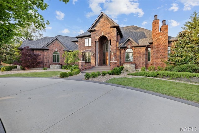 10711 Kennerly Rd, Saint Louis, MO 63128 - view of front facade with brick siding, a front yard, a chimney, and roof with shingles