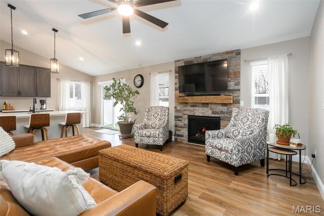 1027 Watering Stone Ct, Pevely, MO 63070 - living area with a fireplace, lofted ceiling, light wood-type flooring, a ceiling fan, and baseboards