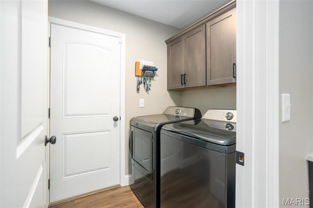 1027 Watering Stone Ct, Pevely, MO 63070 - laundry area featuring washing machine and dryer, cabinet space, and light wood-style floors