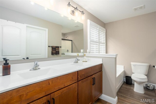 1027 Watering Stone Ct, Pevely, MO 63070 - bathroom featuring wood finished floors, a shower stall, toilet, a garden tub, and double vanity