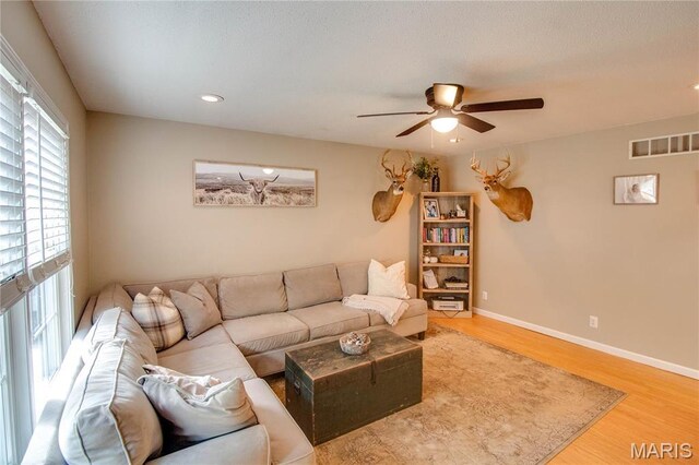 living room featuring ceiling fan, wood finished floors, baseboards, and recessed lighting