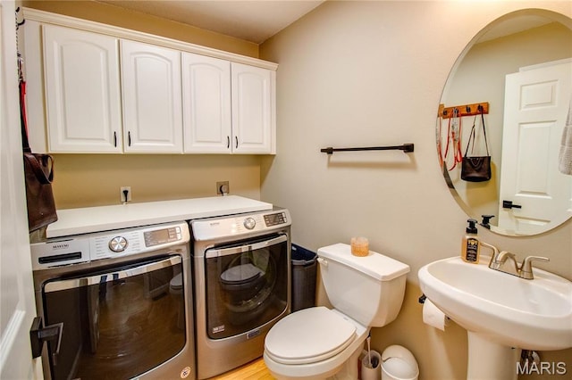 bathroom featuring independent washer and dryer, a sink, and toilet
