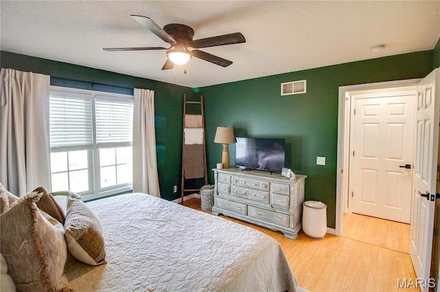 bedroom featuring wood finished floors, baseboards, and a ceiling fan