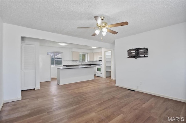 807 Estate Dr, Ofallon, IL 62269 - unfurnished living room featuring ceiling fan, wood finished floors, baseboards, a textured ceiling, and a sink