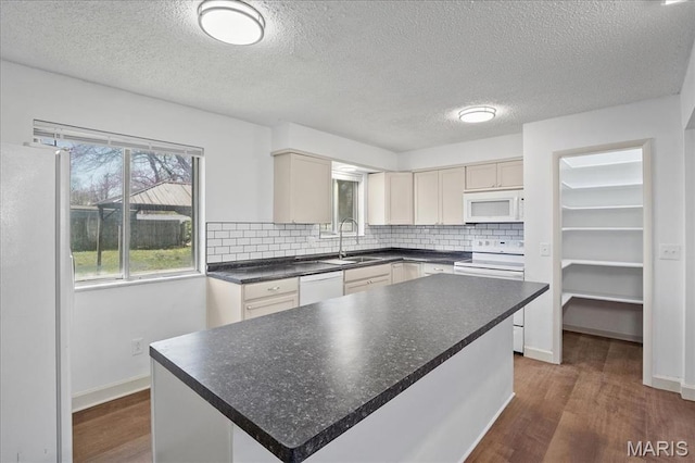 807 Estate Dr, Ofallon, IL 62269 - kitchen with white appliances, a sink, dark wood-type flooring, tasteful backsplash, and a textured ceiling