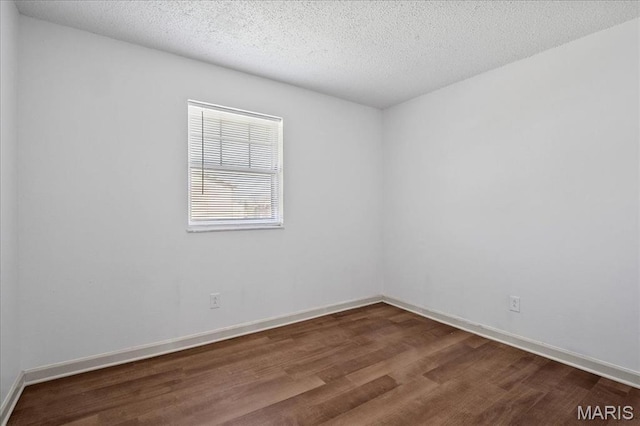 807 Estate Dr, Ofallon, IL 62269 - empty room with dark wood-style flooring, baseboards, and a textured ceiling