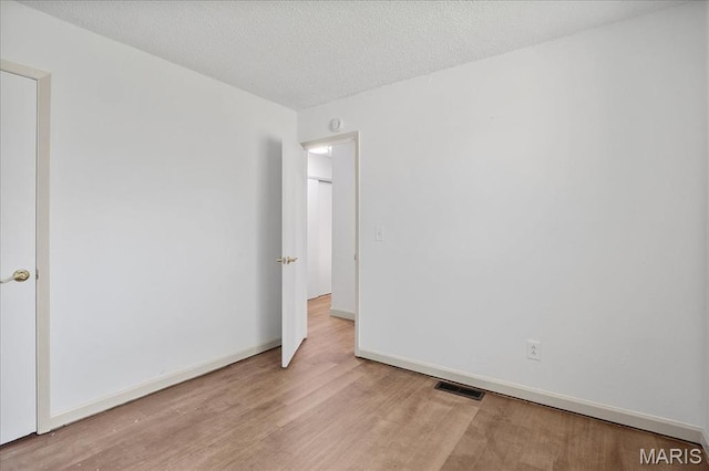 807 Estate Dr, Ofallon, IL 62269 - spare room featuring wood finished floors, baseboards, and a textured ceiling