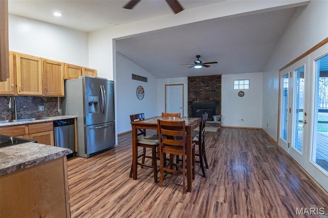 777 Squaw Rd, Cuba, MO 65453 - dining area with a ceiling fan, vaulted ceiling, dark wood-type flooring, a brick fireplace, and baseboards