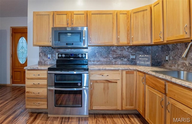 777 Squaw Rd, Cuba, MO 65453 - kitchen with stainless steel appliances, a sink, wood finished floors, and decorative backsplash