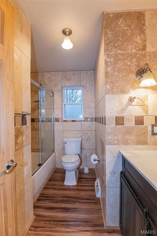 777 Squaw Rd, Cuba, MO 65453 - bathroom featuring tile walls, toilet, wood finished floors, bath / shower combo with glass door, and vanity