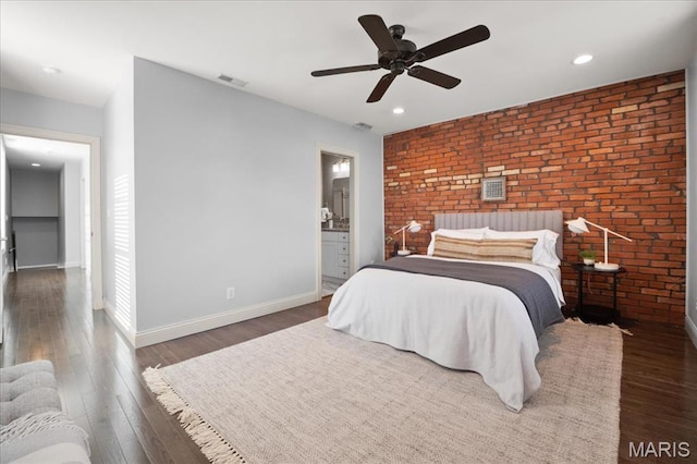 3974 Utah St, Saint Louis, MO 63116 - bedroom with brick wall, wood finished floors, baseboards, recessed lighting, and connected bathroom