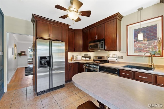 kitchen with stainless steel appliances, a sink, light countertops, and a ceiling fan