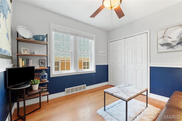 sitting room featuring a ceiling fan, wood finished floors, and baseboards