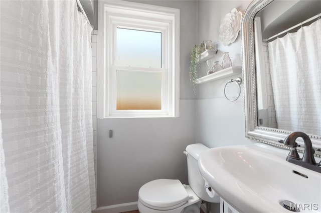 full bathroom with a sink, toilet, and a shower with curtain