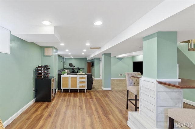 bar featuring baseboards, wood finished floors, and recessed lighting