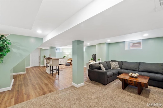 living room featuring baseboards, light wood-style floors, and recessed lighting